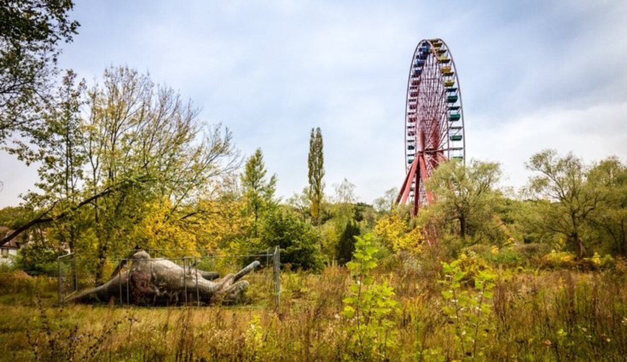 Un parque de atracciones con norias y montañas rusas abandonadas